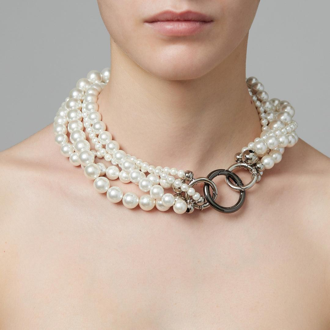 Layered five rows of pearls necklace on model.