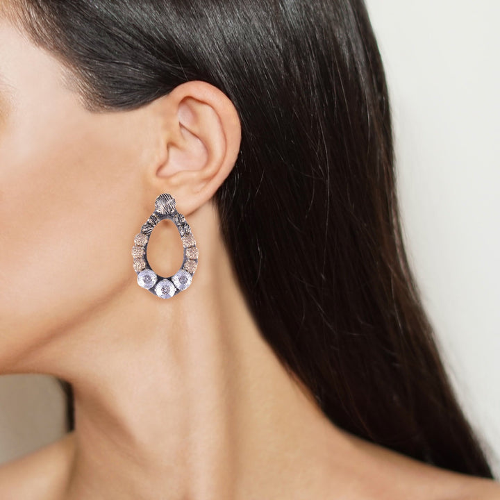 Oval lurex earrings on model.