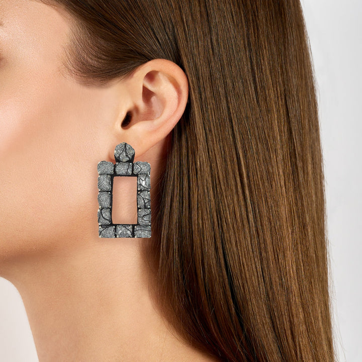 Rectangle lace earrings on model.