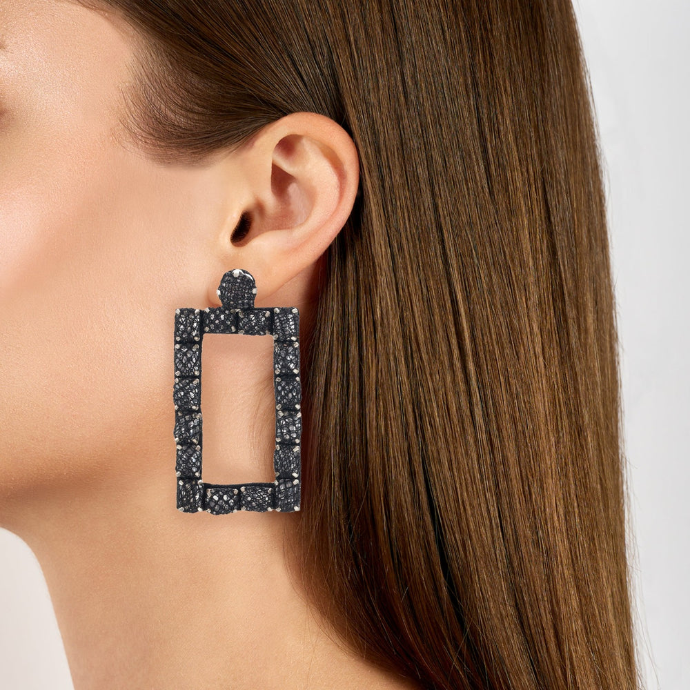 Rectangle lace net earrings on model.